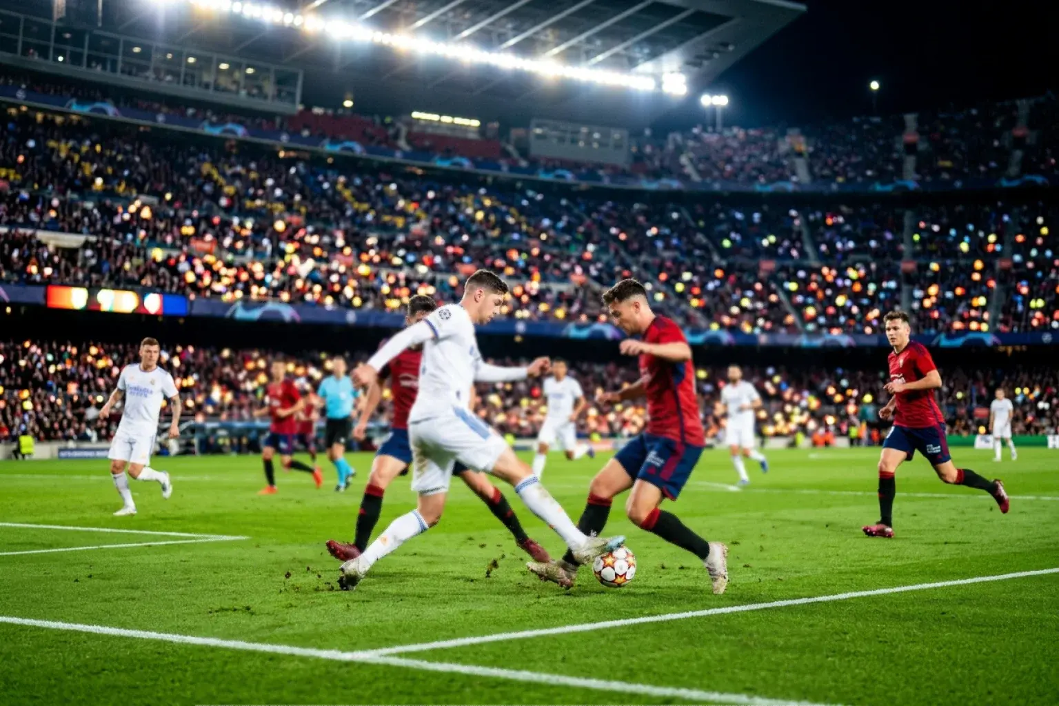 Intenzivna nogometna akcija na travnjaku tijekom večernje utakmice pod reflektorima